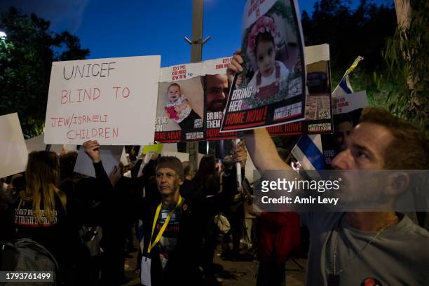 People hold signs with photos of children, who are held hostage in Gaza Strip, during a rally on Novenmber 20, 2023 in Tel Aviv, Israel. Families of...