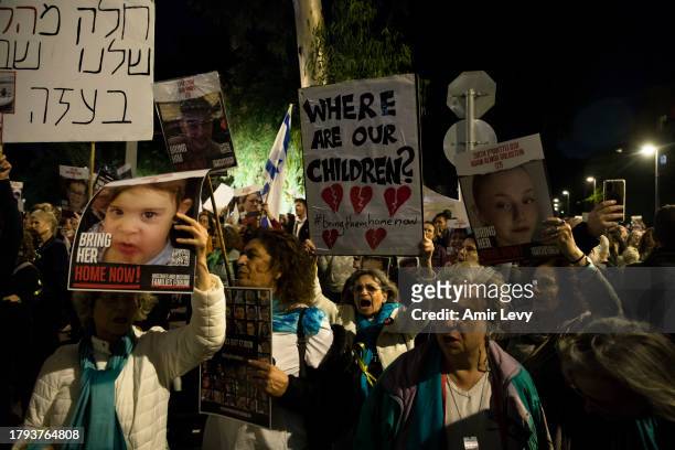 People hold signs with photos of children held hostage in Gaza Strip during a rally outside Tel Aviv's Unicef offices on Novenmber 20, 2023 in Tel...