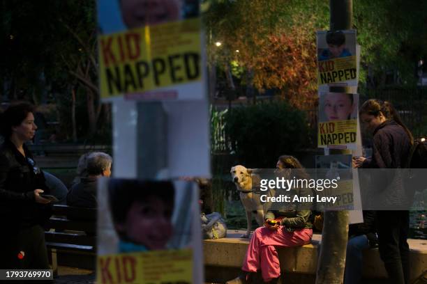 People stand by signs with photos of children held hostage in Gaza Strip during a rally outside Tel Aviv's Unicef offices on Novenmber 20, 2023 in...