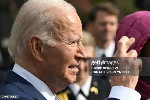 President Joe Biden crosses his fingers while talking about a cease fire in Gaza during the annual Thanksgiving Turkey pardon on the South Lawn of...