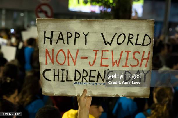 Man holds a sign during a rally outside Tel Aviv's Unicef offices on Novenmber 20, 2023 in Tel Aviv, Israel. Families of hostages and their...