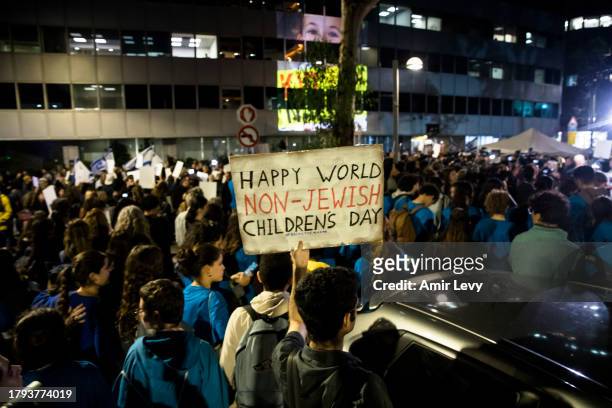 Man holds a sign during a rally outside Tel Aviv's Unicef offices on Novenmber 20, 2023 in Tel Aviv, Israel. Families of hostages and their...