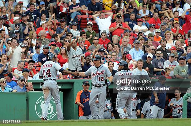 Austin Jackson of the Detroit Tigers receives high fives after scoring a run from teamates Andy Dirks and Prince Fielder in the eighth inning against...