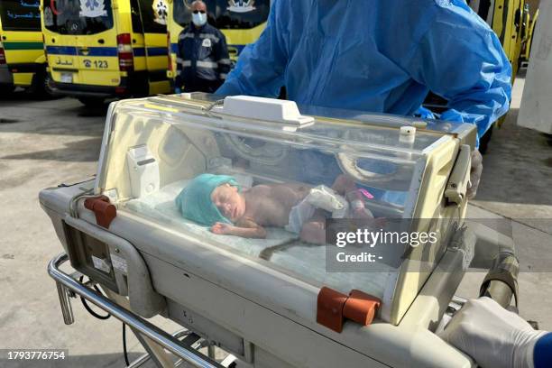 Egyptian medics wheel a premature Palestinian baby evacuated from Gaza to an ambulance on the Egyptian side of the Rafah border crossing with the...