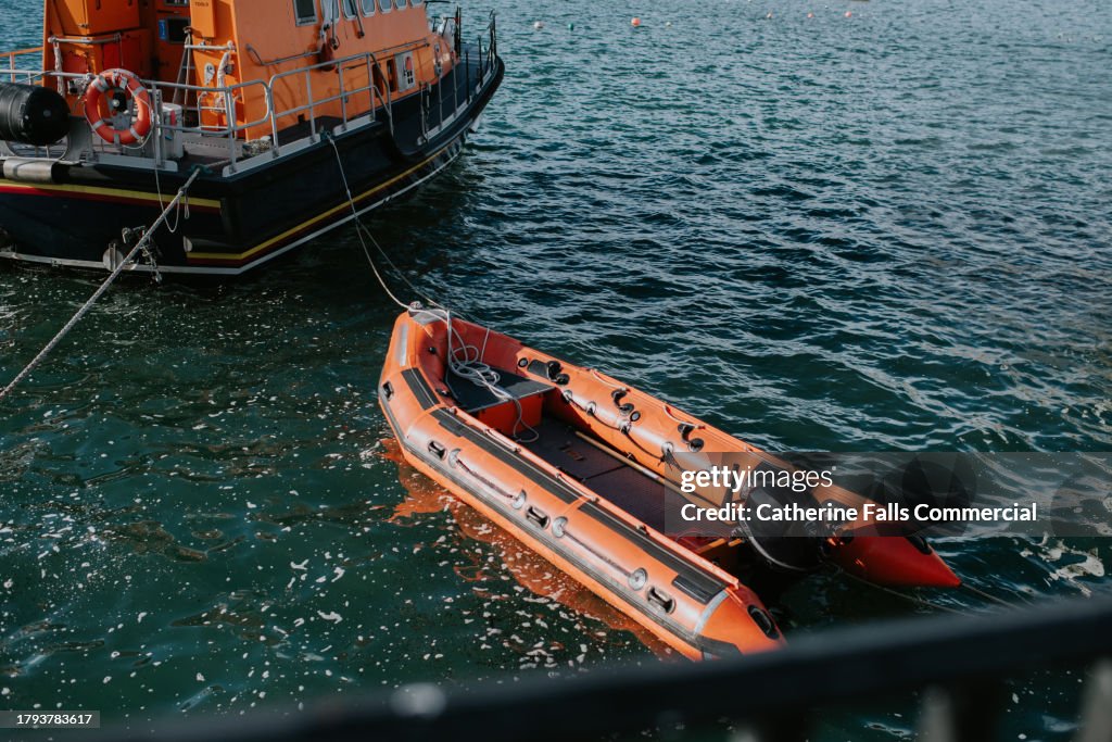 A rescue boat tugs a smaller rescue dingy behind it