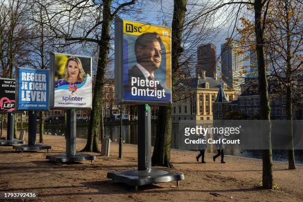 People walk past a campaign poster for the New Social Contract party featuring a featuring a picture of party leader Pieter Omtzigt on November 20,...