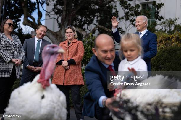 Standing next to his granddaughter Maisy, U.S. President Joe Biden waves after pardoning National Thanksgiving turkeys Liberty and Bell during a...