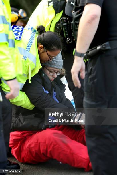 An activist is handcuffed and encouraged to stand before being taken away by police officers on November 20, 2023 in Leicester, United Kingdom....