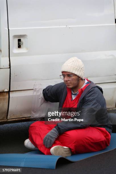 An activist is attached to a lock-on in the body of a van on the southern part of Meridian East, blocking the road to traffic on November 20, 2023 in...