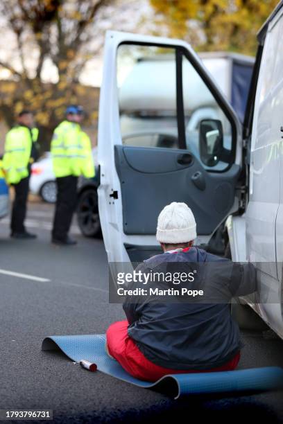 An activist is attached to a lock-on in the body of a van on the southern part of Meridian East, blocking the road to traffic on November 20, 2023 in...