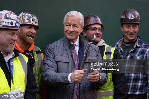 Jamie Dimon, chief executive officer of JPMorgan Chase & Co., takes a photograph with construction workers during an event at 270 Park Avenue,...