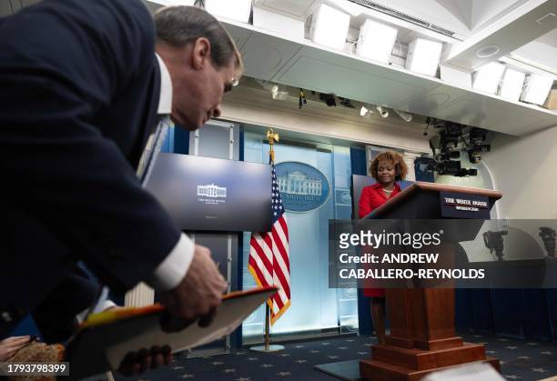 National Security Council spokesman John Kirby stands up to speak as White House press secretary Karine Jean-Pierre looks on during the daily...