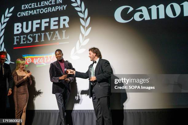 Tope Babaloa presents Liam Death with Excellence in Cinematography award for "The Delivery". Buffer Festival in Toronto is an annual celebration of...