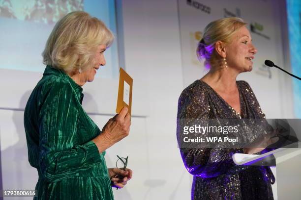 Queen Camilla receives honorary a membership from Foreign Press Association director Deborah Bonetti as she attends The Foreign Press Association...