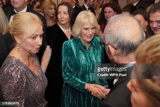 Queen Camilla speaks to a guest at the annual awards ceremony which is celebrating its 135th anniversary at Sheraton Grand London Park Lane on...