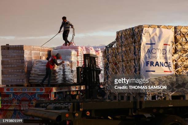 Egyptian Red Crescent members load on a truck humanitarian aid for war-torn Gaza brought by a French air force Airbus A400M cargo aircraft at...