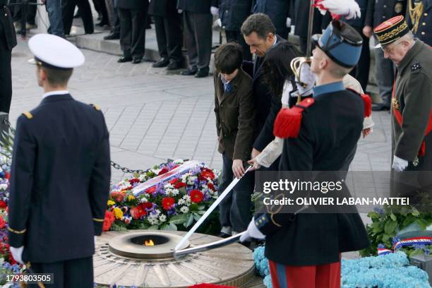 French President Nicolas Sarkozy lights the flame at the tomb of the unknown soldier beneath the Arc de Triomphe during the Armistice Day ceremony in...