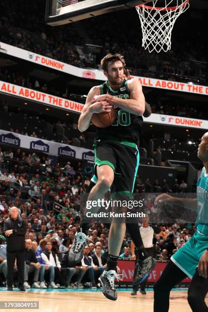 Luke Kornet of the Boston Celtics grabs a rebound during the game against the Charlotte Hornets on November 20, 2023 at Spectrum Center in Charlotte,...