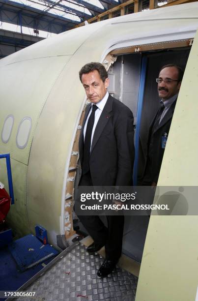 French President Nicolas Sarkozy and Jean-Paul Miquel, head of assembly line, go out of a A330 Airbus in built, 18 May 2007 at the Airbus plant in...