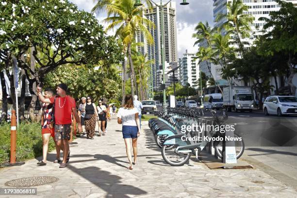 Tourists stroll down Kalakaua Avenue along Waikiki Beach in Honolulu on Hawaii's Oahu island on Nov. 17, 2023.