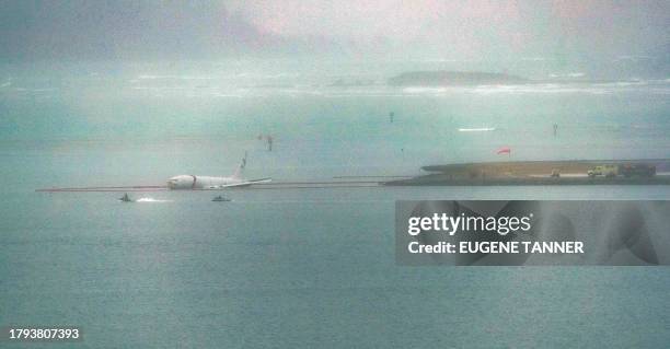 Military aircraft is seen in the shallow waters of Kaneohe Bay after skidding off the end of the runway at Marine Corps Hawaii in Kaneohe on November...