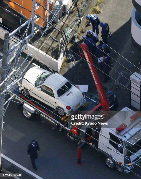 Photo taken on Nov. 21 from a Kyodo News helicopter shows a minicar being transported after it veered into a group of pedestrians in Umi, Fukuoka...