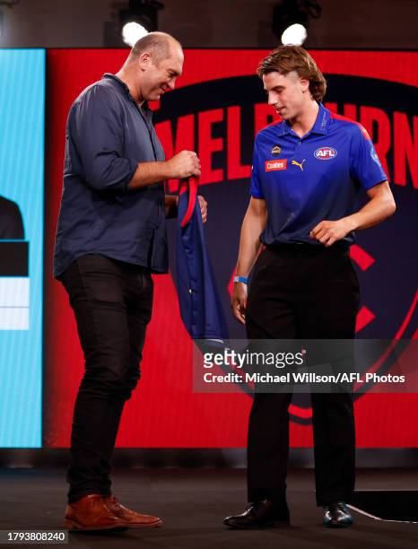 Caleb Windsor is seen with David Neitz after being selected at number seven by the Melbourne Demons during the 2023 AFL Draft at Marvel Stadium on...
