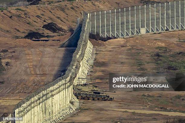 This picture taken from southern Israel near the border with Gaza shows an Israeli army tank exiting the security barrier surrounding the Palestinian...