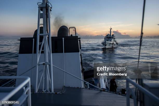 Philippine Coast Guard personnel looks out at a China Coast Guard ship during a resupply mission for the BRP Sierra Madre, in the Second Thomas Shoal...