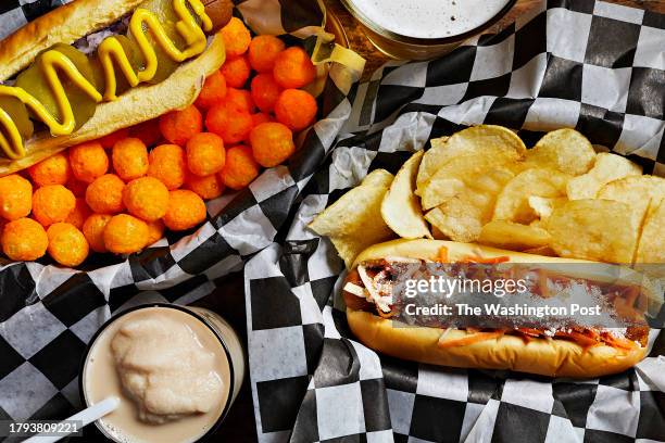 Left to right: The veggie Jess Dog - sliced pickles, red onions, mustard on a potato bun with cheese balls and the veggie Lymans Dog with curtido,...