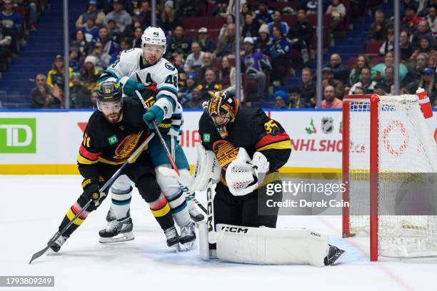 Thatcher Demko makes a save as Mark Friedman of the Vancouver Canucks defends Tomas Hertl of the San Jose Sharks during the third period of their NHL...