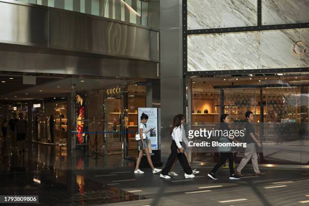 Shoppers walk past a Gucci store in Singapore, on Monday, Nov. 20, 2023. Singapore's gross domestic product figures for the third quarter are...