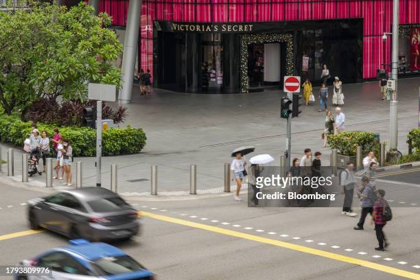 Pedestrians cross a road on Orchard Road in Singapore, on Monday, Nov. 20, 2023. PSingapore's gross domestic product figures for the third quarter...