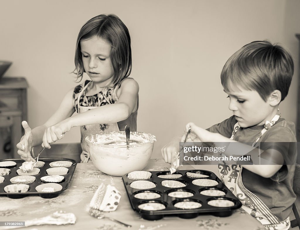Young boy and girl make cakes