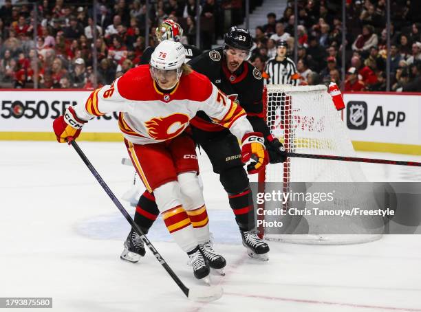 Martin Pospisil of the Calgary Flames battles with Travis Hamonic of the Ottawa Senators at Canadian Tire Centre on November 11, 2023 in Ottawa,...