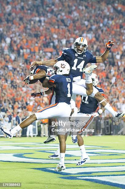 Running back Corey Grant of the Auburn Tigers celebrates with teammates wide receiver Trovon Reed, quarterback Nick Marshall and tight end Brandon...