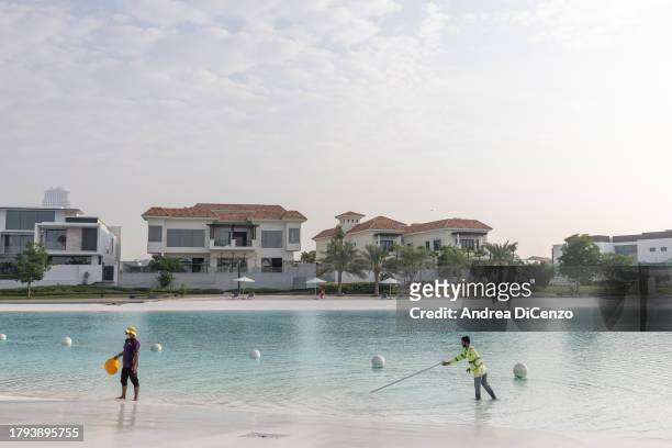 Workers clean the fresh water lagoon at District One on November 21, 2023 in Dubai, United Arab Emirates. District One is building the world's...