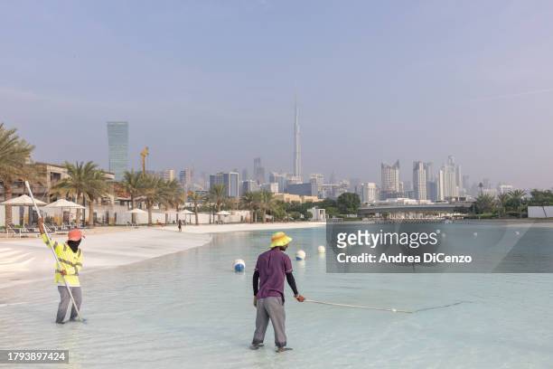 Workers clean the fresh water lagoon at District One on November 21, 2023 in Dubai, United Arab Emirates. District One is building the world's...