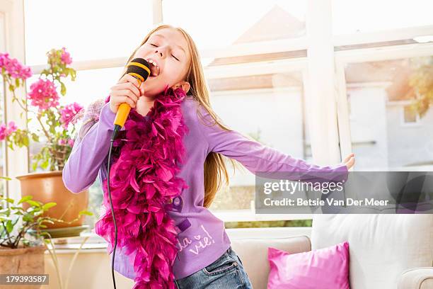 young girl singing kareoke at home. - girl singing imagens e fotografias de stock