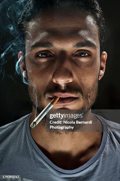 portrait of a guy smoking a cigarette - im mund tragen stock-fotos und bilder