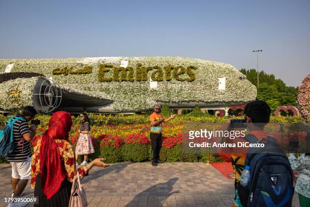 Tourists pose for pictures at the Dubai Miracle Garden, home to over 150 million flowers, on November 8, 2023 in Dubai, United Arab Emirates. In the...