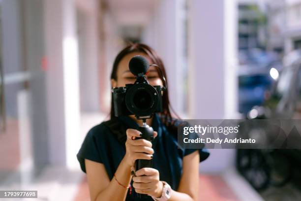 asian girl vlogging with mirrorless camera and mic - mirrorless camera bildbanksfoton och bilder