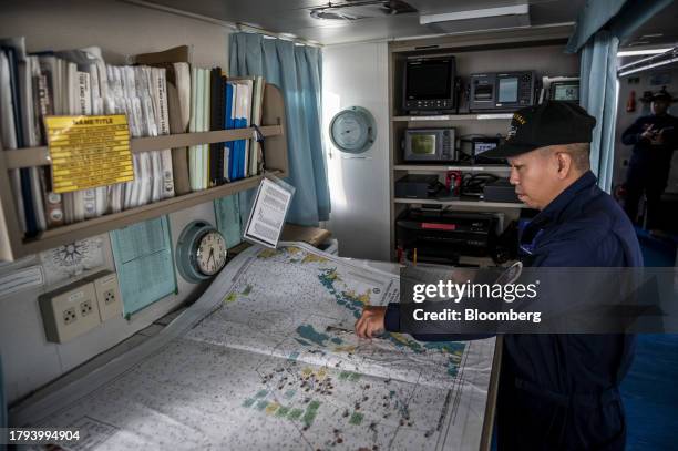 Philippine Coast Guard personnel shows a map of Kalayaan Island Group on BRP Sindangan, before departing for a resupply mission for the BRP Sierra...