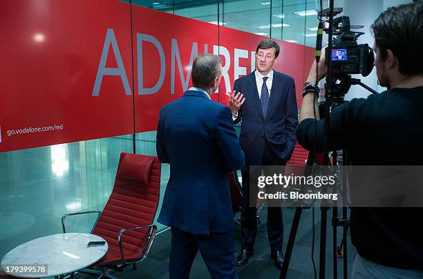 Vittorio Colao, chief executive officer of Vodafone Group Plc, center, gestures during a Bloomberg Television interview in London, U.K., on Monday,...