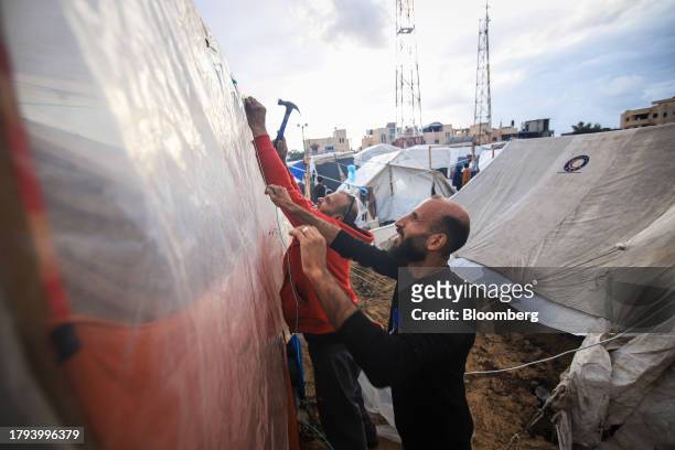 Displaced Palestinians build temporary shelters at a camp, operated by the United Nations Relief and Works Agency , in Khan Younis, Gaza, on Sunday,...