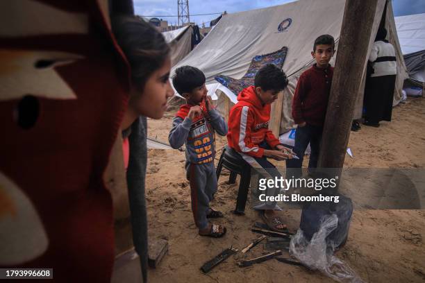 Displaced Palestinian children outside temporary shelters at a camp, operated by the United Nations Relief and Works Agency , in Khan Younis, Gaza,...