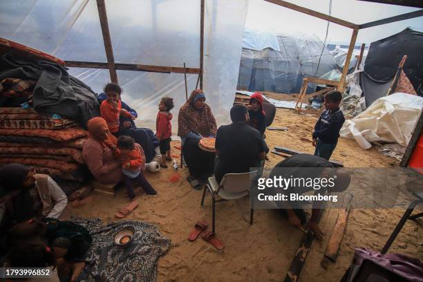 Displaced Palestinians in a temporary shelter under construction at a camp, operated by the United Nations Relief and Works Agency , in Khan Younis,...