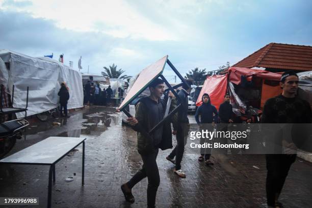 Palestinian man carries an item of furniture at a temporary camp, operated by the United Nations Relief and Works Agency , in Khan Younis, Gaza, on...