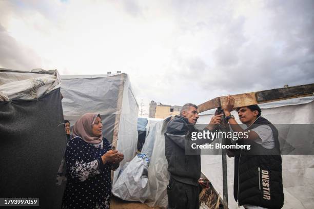 Displaced Palestinians build temporary shelters at a camp, operated by the United Nations Relief and Works Agency , in Khan Younis, Gaza, on Sunday,...