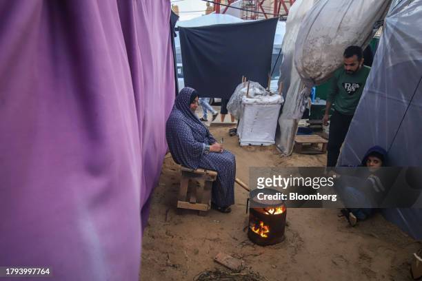 Displaced Palestinians cook food in a temporary shelter at a camp, operated by the United Nations Relief and Works Agency , in Khan Younis, Gaza, on...